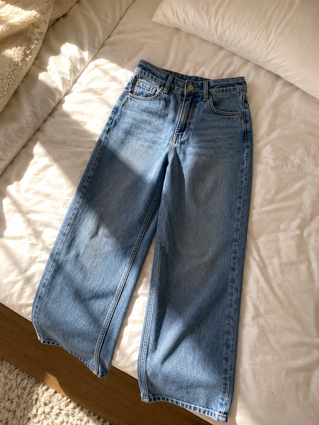 Jeans photographed on a bed